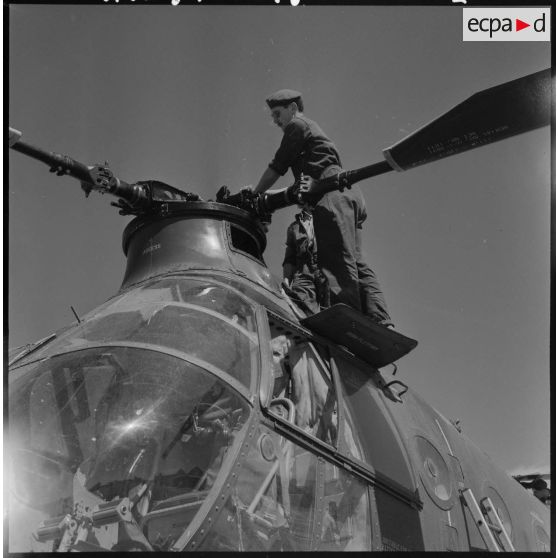 Setif - Aïn Arnat. Des militaires entretiennent les pales d'un hélicoptère Piasecki  de la base héliport Maréchal de Lattre.