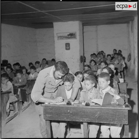 Centre de regroupement de Sahel. L'instituteur parmi ses élèves.