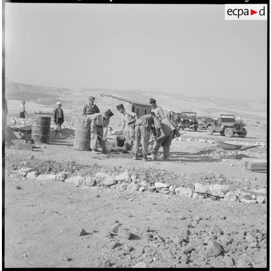 Centre de regroupement de Baudens. Militaires du 129e régiment d'infanterie (RI) travaillant au ciment.