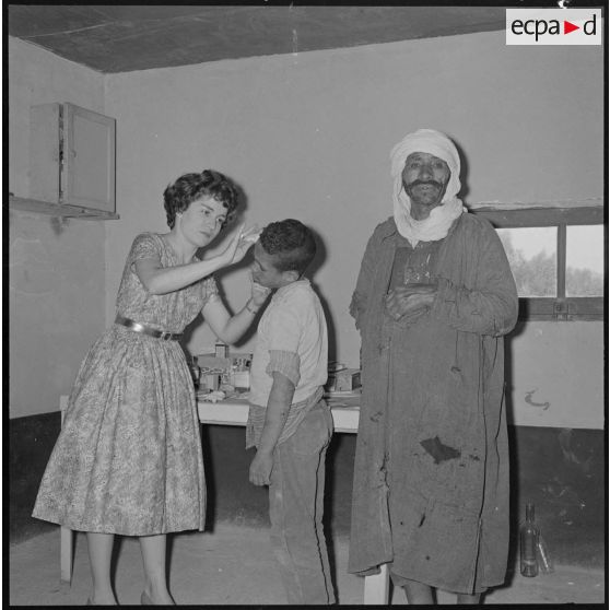 Centre de regroupement d'Ouled Ali. Assistante sociale soignant un enfant.