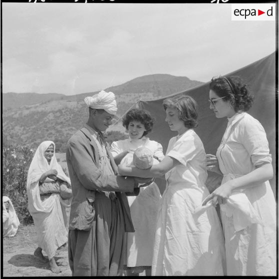 Secteur de Miliana. Après avoir donné les soins au nourrisson, les trois adjointes sanitaires et sociales rurales auxiliaires (ASSRA) le remettent au père.