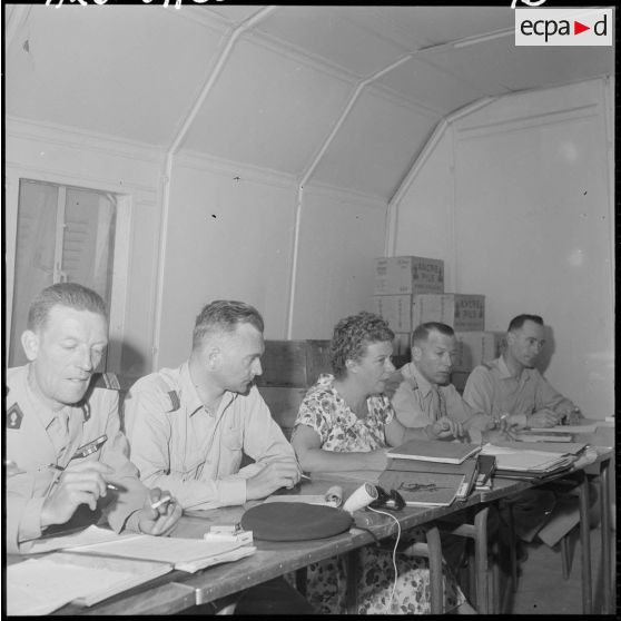 Orléansville. Le commandant Guize du 5e Bureau d'Alger, le commandant Presta du 5e bureau d'Orléansville, madame Leroux, chef des ASSRA (adjointes sanitaires et sociales rurales auxiliaires), le capitaine Guizol du 5e bureau de la zone ouest algérois (ZOA) pendant la réunion des ASSRA.