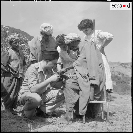 Secteur de Miliana. Un homme du groupe d'auto-défense du douar d'Oued-el-Haad se fait soigner par le médecin de la section administrative spécialisée (SAS) du Zaccar.