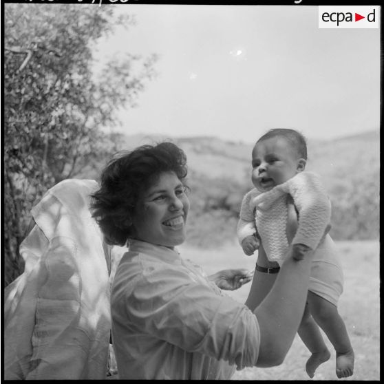 Secteur de Miliana. Une adjointe sanitaire et sociale rurale auxiliaire (ASSRA) prend dans ses bras le nourrisson nettoyé et changé.