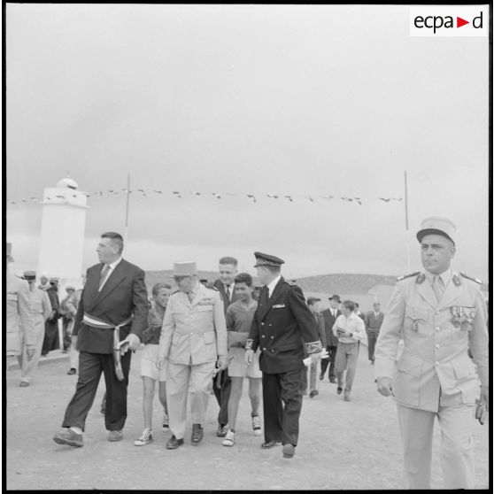 Centre de regroupement de Zelemta. Le général Gambiez marche avec les autorités, accompagnés d'enfants.