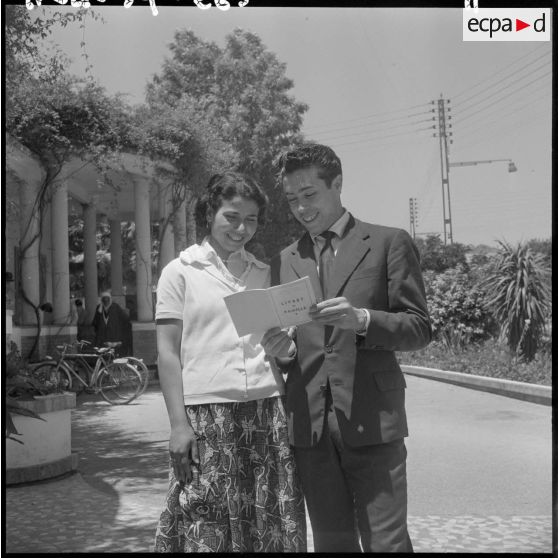 Mariage musulman" en Algérie. Portrait des mariés lisant leur livret de famille.
