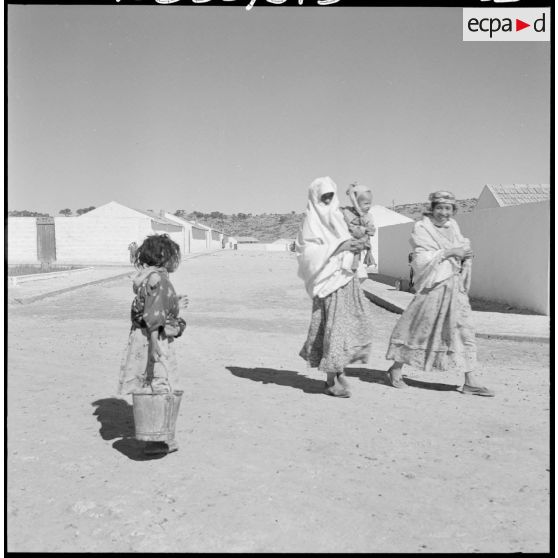 Centre de regroupement de Zelemta. Femmes et enfants dans une rue.