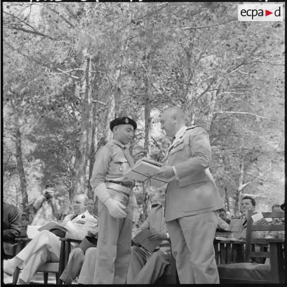 Le colonel Lehir, commandant du 2e régiment de parachutistes coloniaux (2e RPC), remet un prix d'excellence à un élève dans les jardins de l'Ecole militaire préparatoire nord africaine (EMPNA) de Koléa.