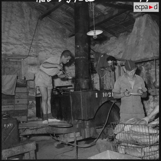 Guelma. 151e régiment d'infanterie motorisée (RIM). La cuisine roulante est installée à l'abri et un caporal 57/2A goûte si la soupe est bonne.