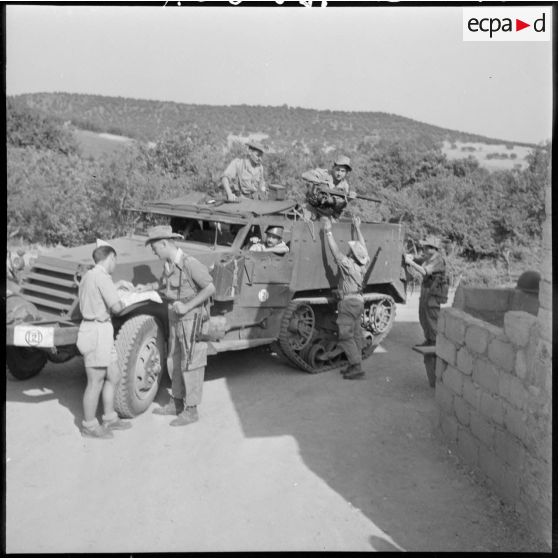 Guelma. 151e régiment d'infanterie motorisée (RIM). Vite il faut une patrouille blindée, un sergent 57/1B  regarde la carte pendant que l'équipage prépare l'half-track (H.T).
