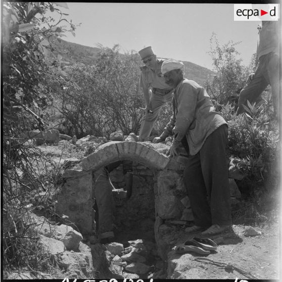 Construction d'une fontaine à côté d'un regroupement en montagne, supervisée par le capitaine Doeffer.