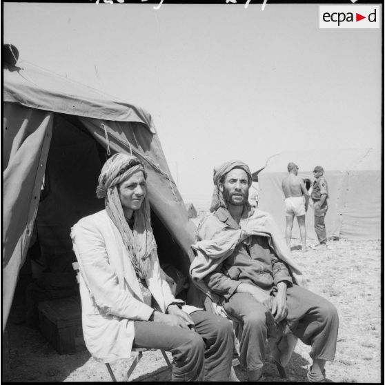Portrait de deux prisonniers enterrés vivants sous des cailloux, libérés par les parachutistes.