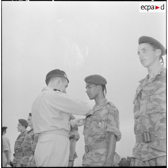 Le général Gilles, commandant les troupes aéroportées, en visite à la base aéroportée de Blida : remise de décoration.