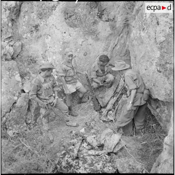 Le matelot Marie de la 1re demi-brigade de fusiliers-marins (1re DBFM) sort les mirailleuses de la cache, creusée dans les rochers.