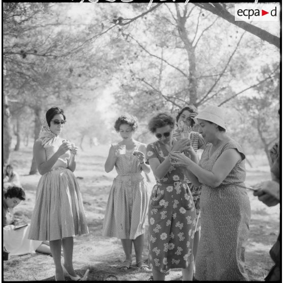Jeunes femmes et enfants à la campagne, sous la direction de mesdames Godard et Santini, du service de formation des jeunes en Algérie (SFJA).