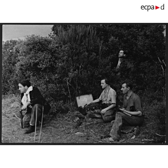 Libération de la Corse. Un opérateur radio transmet un message sur un poste émetteur-récepteur, sous la protection de résistants corses équipés de pistolets-mitrailleurs Sten Mk II.