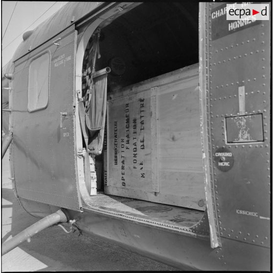 Vue du réfrigérateur à bord de l'hélicoptère H-19 sur l'aérodrome de Maison-Blanche, à destination du poste de Taguemount El Djedid en Kabylie.