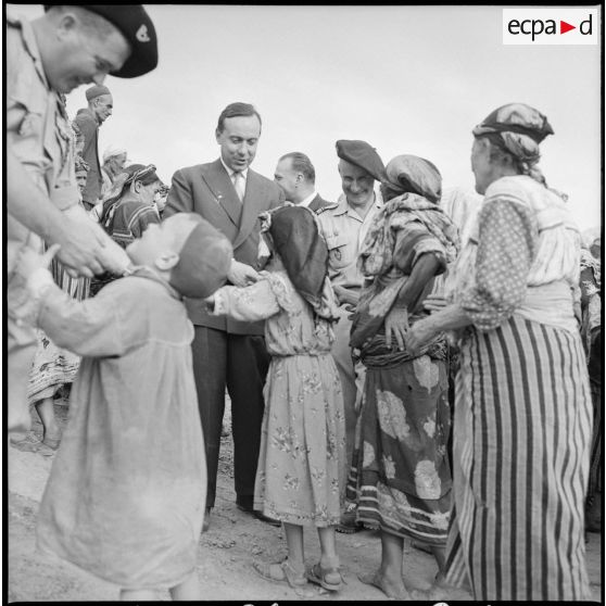 Le Premier ministre Michel Debré et le délégué général Paul Delouvrier serrent les mains des femmes du village de Tikichourt.