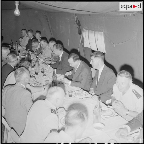 Le Premier ministre Michel Debré et sa suite déjeunent sous une tente au poste de commandement de l'opération "Jumelles".