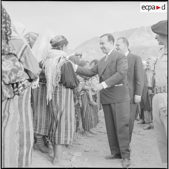 Le Premier ministre Michel Debré et le délégué général Paul Delouvrier serrent les mains des femmes du village de Tikichourt.