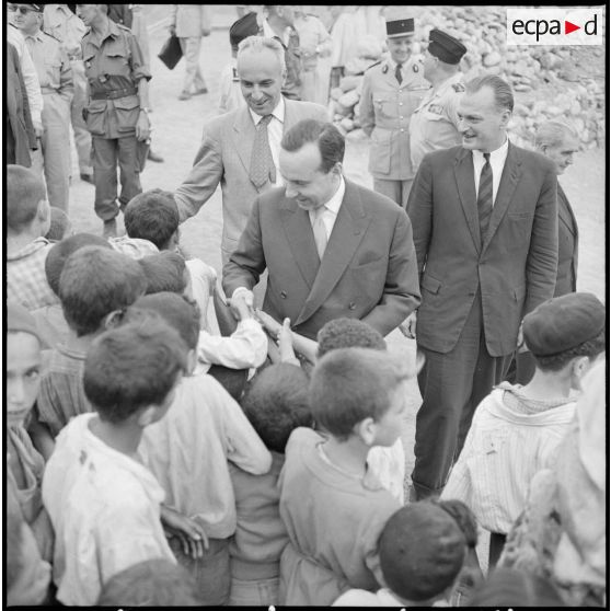 Le Premier ministre Michel Debré, le ministre des Armées Paul Guillaumat, et le délégué général Paul Delouvrier reçoivent un accueil chaleureux de la part des enfants du village de Tikichourt.