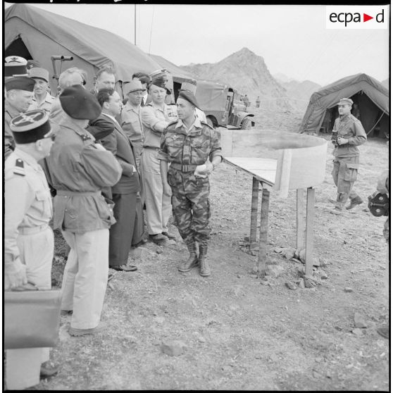 Le colonel Ceccaldi, commandant le poste de commandement (PC) Artois, fait au Premier ministre Michel Debré et à sa suite un exposé de l'opération devant une vue panoramique de la région.