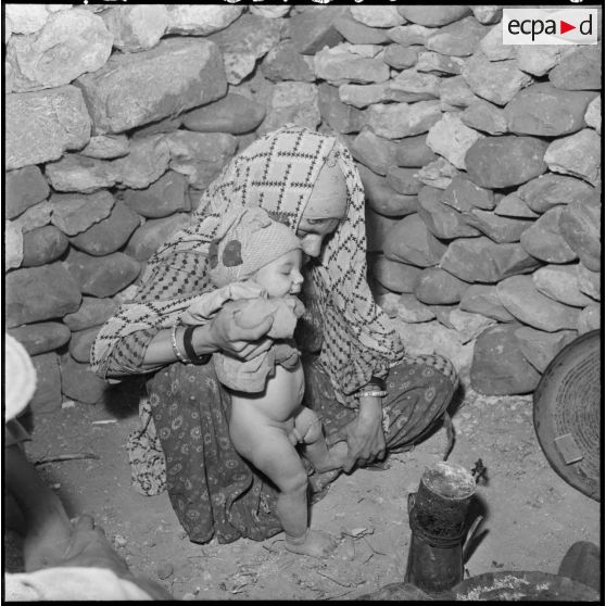 Portrait d'une femme et de son enfant pendant la préparation du repas au centre de Sidi Naâmane.