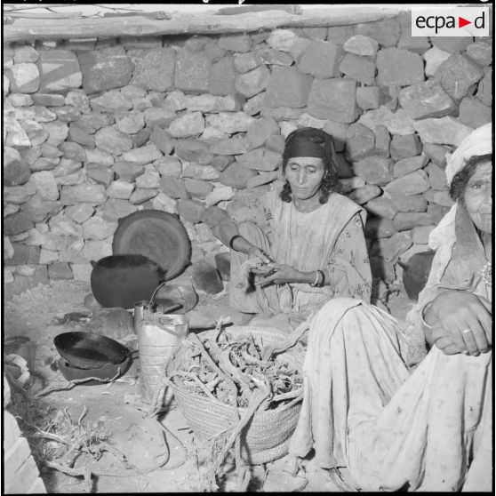 Scène de la vie quotidienne au centre de regroupement de Sidi Naâmane : une femme prépare le repas.