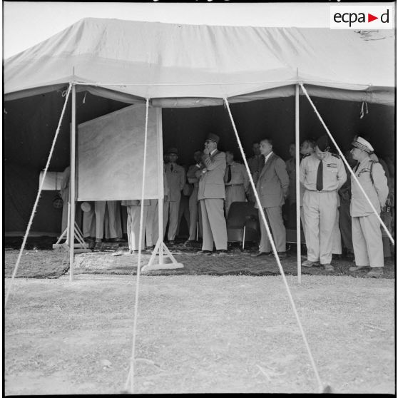 Le général de Gaulle en réunion d'information avec des autorités, sous une tente, à Renault.
