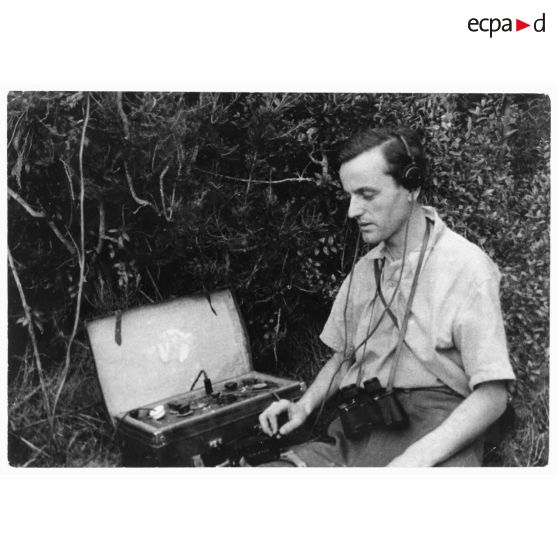 Un opérateur radio émet un message sur un poste émetteur-récepteur (valise radio) dans le maquis corse.