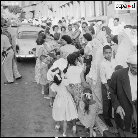 Rassemblement des élèves accompagnés par leurs parents devant l'entrée de l'école primaire.