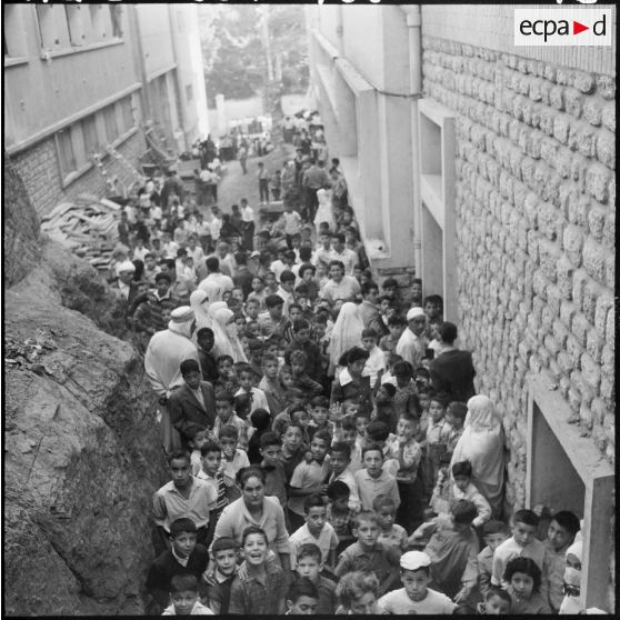 Rassemblement des élèves accompagnés par leurs parents devant l'école avant l'ouverture des portes.
