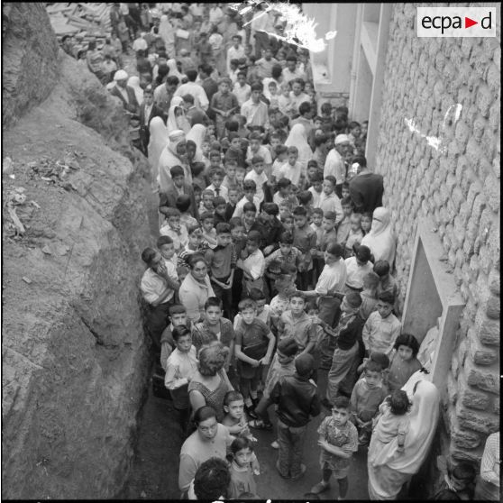 Rassemblement des élèves accompagnés par leurs parents devant l'école avant l'ouverture des portes.