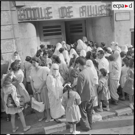 Rassemblement des élèves accompagnés par leurs parents devant l'entrée de l'école de filles.