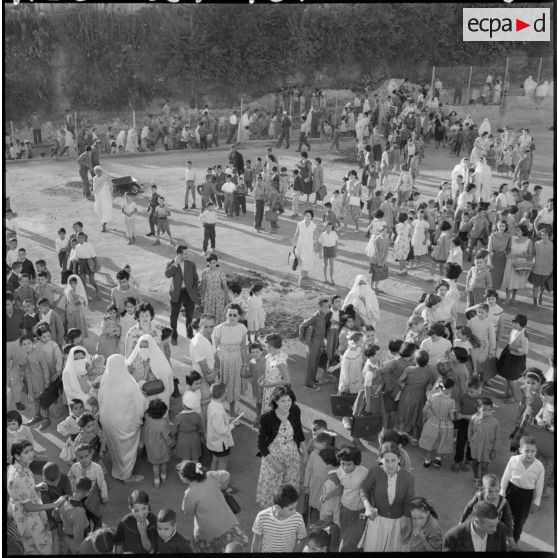 Rassemblement des élèves accompagnés par leurs parents devant l'entrée de l'école.