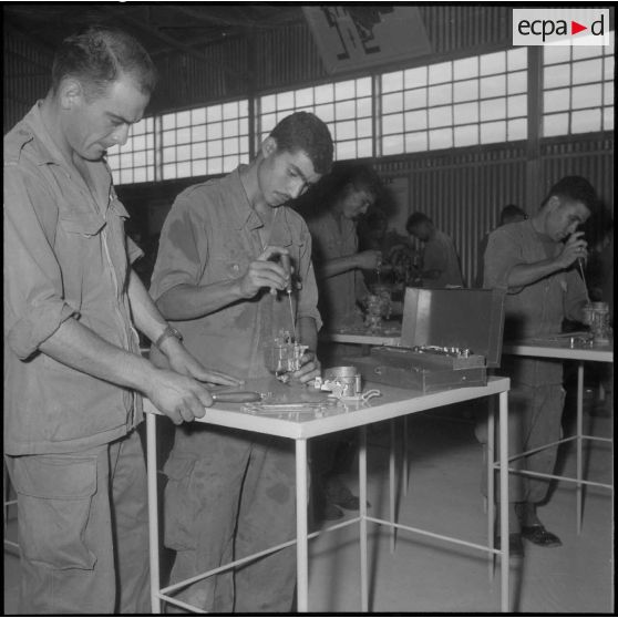 Au Centre d'instruction de Français de souche nord-africaine (FSNA) CISM 3 de l'Alma, démontage du carburateur d'un moteur sous le regard d'un instructeur.