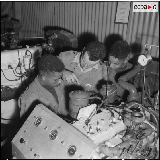 Cours de mécanique au Centre d'instruction de Français de souche nord-africaine (FSNA) CISM 3 de l'Alma : autour du filtre à huile d'un moteur de Jeep.