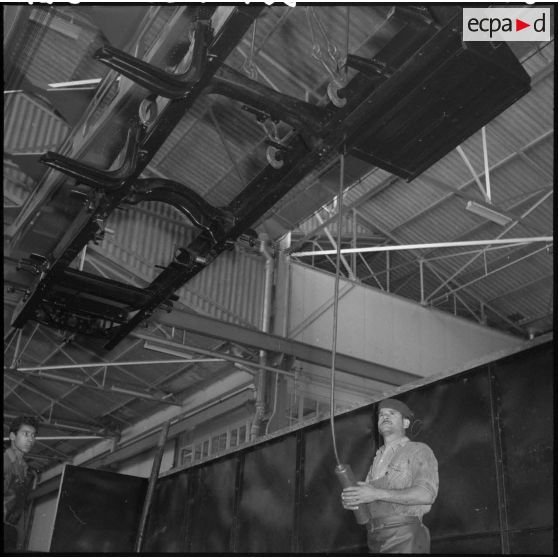 La chaîne de montage de camions de la Société Africaine des automobiles Berliet à Rouiba : Manutention d'un châssis à l'aide de potences et ponts roulants.