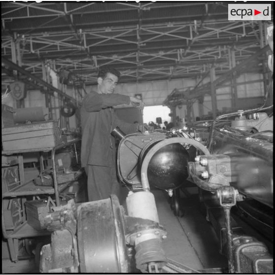 La chaîne de montage de camions de la Société Africaine des automobiles Berliet à Rouiba : pose d'un réservoir à carburant.
