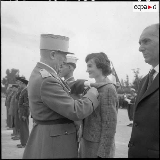 Relizane. Mademoiselle Bertrand, adjointe sanitaire et sociale rurale auxiliaire (ASSRA) de Relizane, reçoit la valeur militaire des mains du colonel Terce.