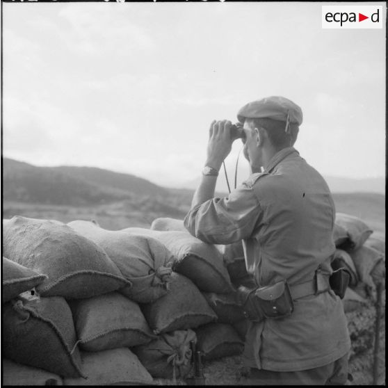 Le 2e classe Odier Yves (58 I/B), originaire de St Marcelin (Isère) et mouleur dans le civil surveille aux  jumelles la frontière toute proche.