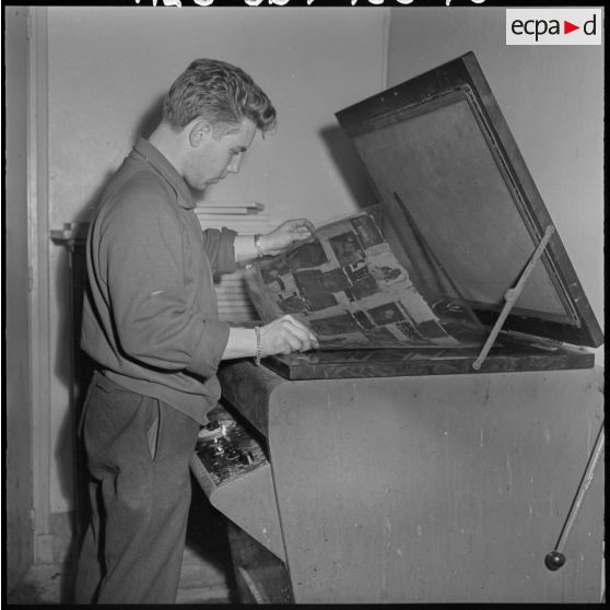 Un employé de l'imprimerie du 5e bureau travaille à la création d'une affiche de propagande.