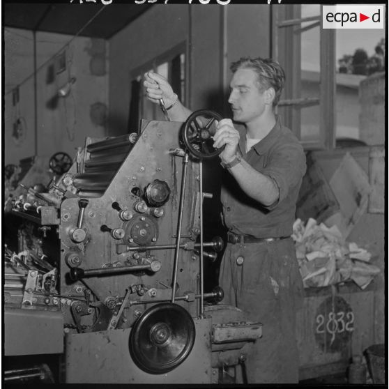 Un travailleur de l'imprimerie du 5e bureau sur une presse d'impression rotative.