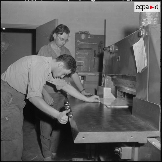 Deux employés de l'imprimerie du 5e bureau travaillent à la création d'une affiche de propagande.