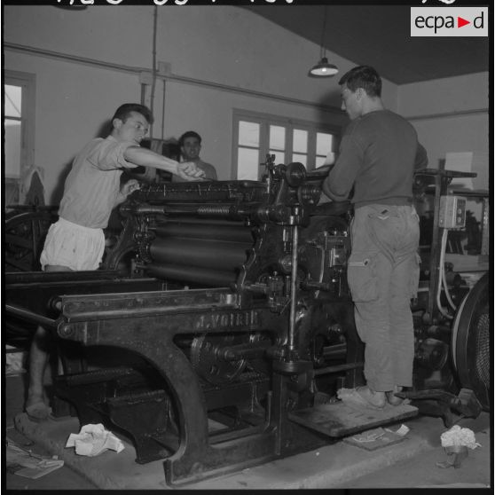 Des travailleurs de l'imprimerie du 5e bureau sur une presse d'impression rotative.