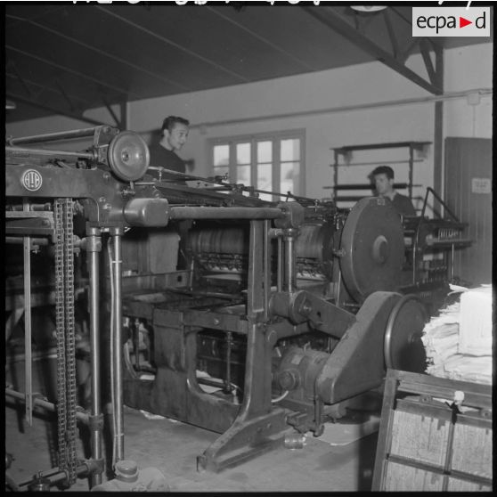 Un travailleur de l'imprimerie du 5e bureau sur une presse d'impression rotative.