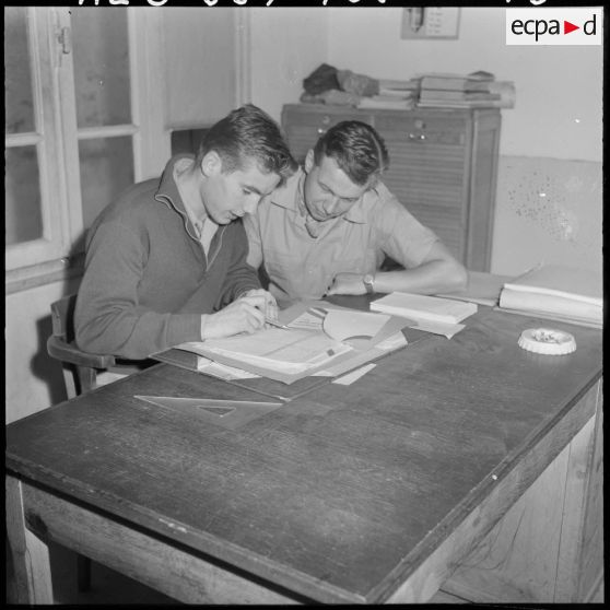 Deux employés de l'imprimerie du 5e bureau travaillent à la création d'une affiche de propagande.