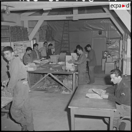 Des employés de l'imprimerie du 5e bureau à l'intérieur du local d'envois et de réception de colis.