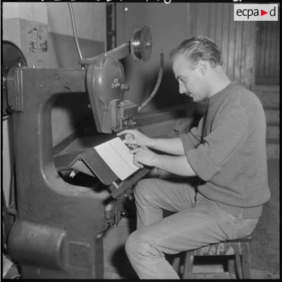 Un employé de l'imprimerie du 5e bureau travaille à la création d'une affiche de propagande.