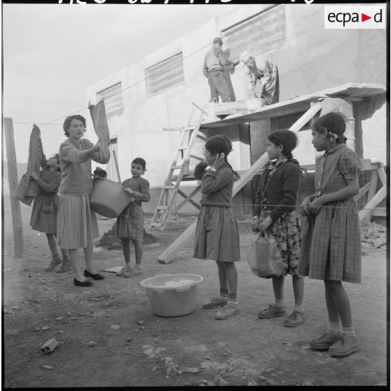 Les jeunes filles de l'ouvroir de la section administrative spécialisée (SAS) dépendent le linge, assistées par Mme Louis, présidente locale du mouvement de solidarité féminine de Cheraïa.